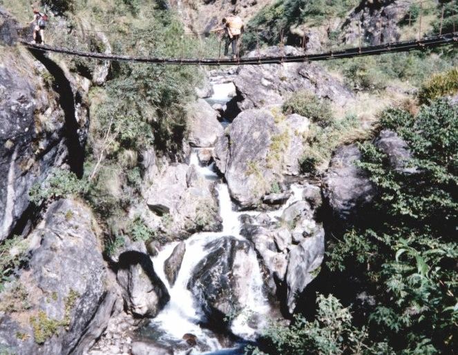 Nepalese Porter crossing a Suspension Footbridge over Laba Khola