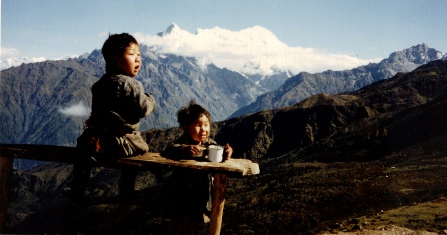 Nepalese children and Mount Langtang Lirung ( 7227m ) on ascent from Syabru to Gosaikund