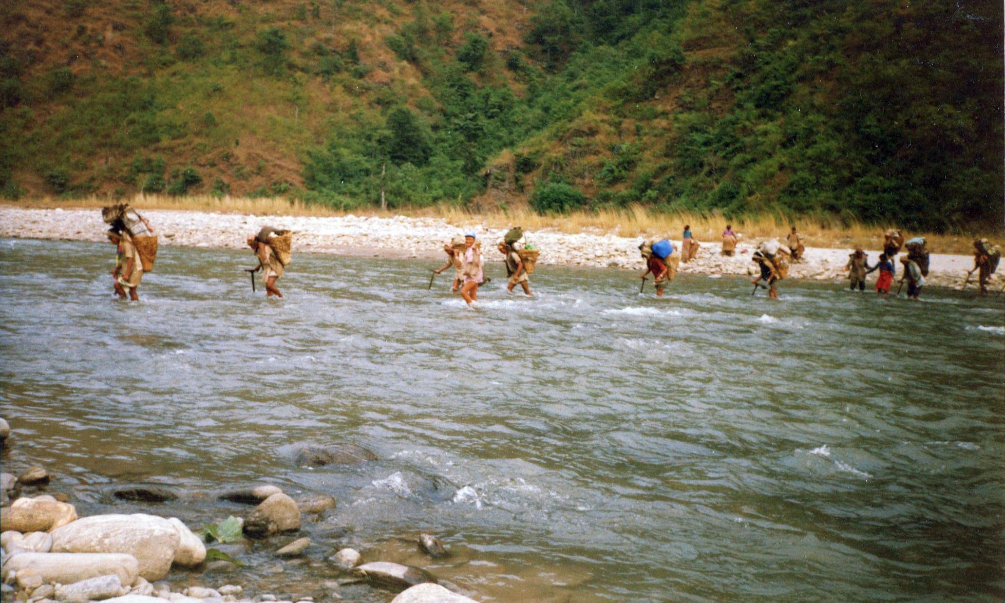 Trekking Porters fording the Piluwa Khola in the Arun Valley