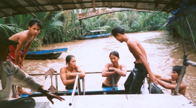 Vietnamese Boy swimmers in narrow waterway of Mekong Delta