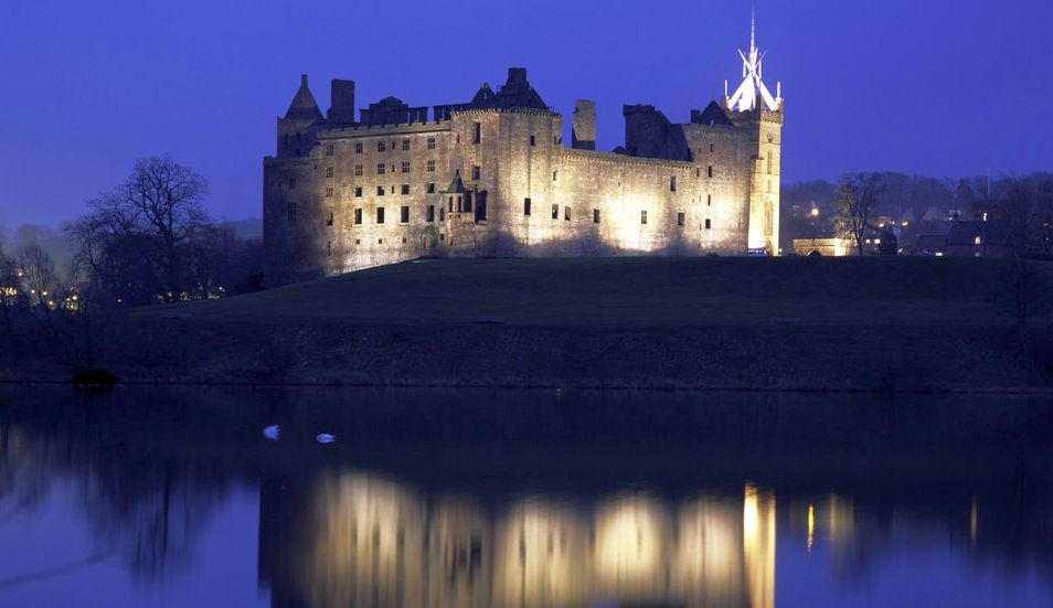 Linlithgow Palace and St Michael's Church from the Loch illuminated at night