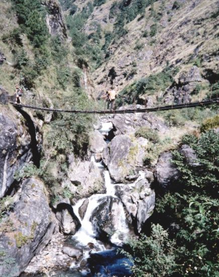 Nepalese Porter crossing a Suspension Footbridge over Laba Khola